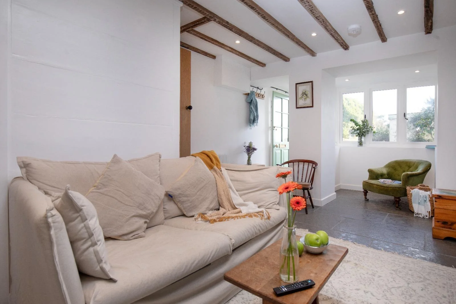 Living room with sofa, exposed beams and garden door
